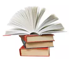 open book on top of stack of books isolated on white background