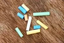 colorful pieces of chalk on a brown, wood background