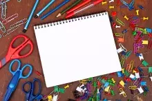 pad of paper with scissors, paper clips, pens, thumb tacks