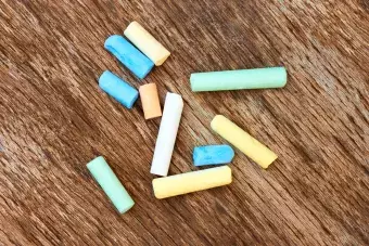 colorful pieces of chalk on a brown, wood background