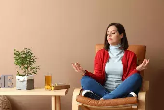 woman sitting in a chair doing a yoga move