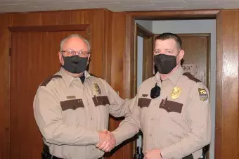 Conservation Executive Director Roger Kean shaking new Park Ranger Brad Taylor's hand. 