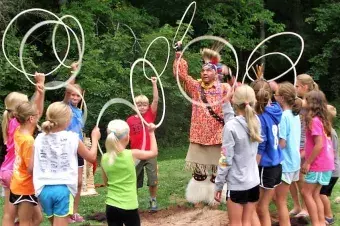 Campers playing with hula-hoops during an indian presentation.
