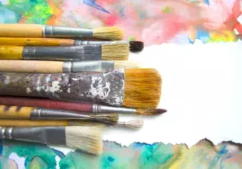 A group of paintbrushes on abstract colorful watercolor background 