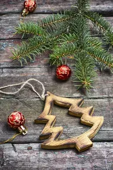 Ornaments and pine branch on wood surface