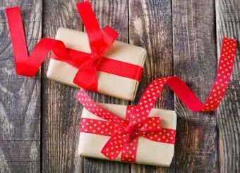 box for present with red ribbon on the wooden table