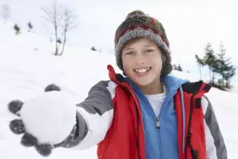 Pre-teen boy holding snowball