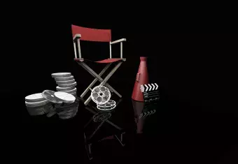 This is a picture of a director's chair, bull horn and film reel