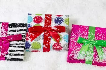 Closeup horizontal view of holiday wrapped gifts placed on snow