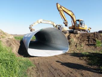Culvert being lowered into the ground.
