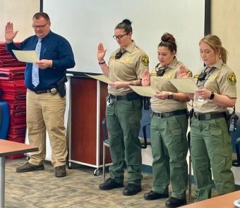 Three corrections officers being sworn in.