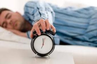 Man sleeping with alarm clock.