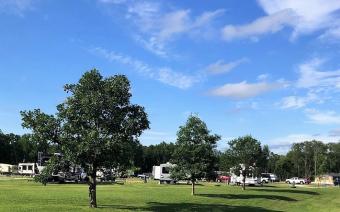 View of Woodside campground with blue sky and trees.