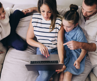 Picture of a family looking at a laptop together to create their emergency plan