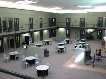 The jail housing area interior with tables and seating.