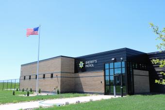 Sheriff Patrol Headquarters building with flag flying in foreground.