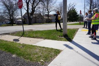 Group of people on public sidewalk at an intersection.