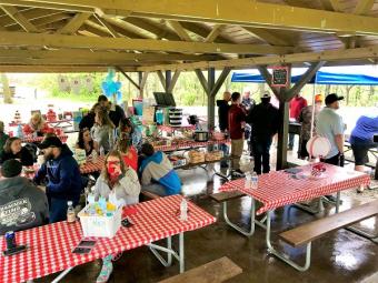 Shelter filled with people gathering for a baby shower.