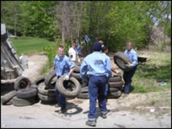 Inmates cleaning up tires.