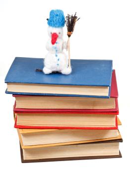 felt soft toy snowman on stack of books isolated on white background