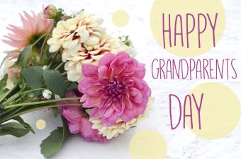 Bouquet of colored dahlias on wooden background with the words "Happy Grandparents Day"