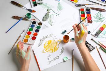 Artist painting picture at table