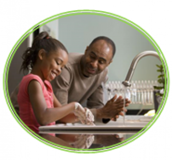 Image of young girl washing her hands while an adult stands near to demonstrate the correct actions