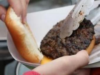 Image of a hamburger being placed on a bun.