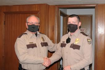 Conservation Executive Director Roger Kean shaking new Park Ranger Brad Taylor's hand. 