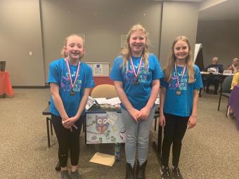 Photograph of 3 girls wearing medals