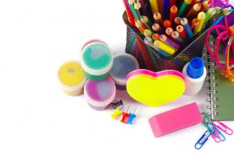 A group of craft supplies, including paint, colored pencils, and stationery. 