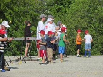 a photo of kids learning to cast fishing poles