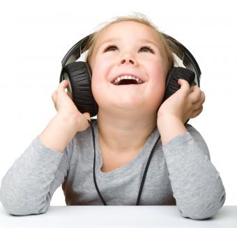 little girl enjoying music using headphones, isolated over white