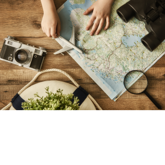 Map, magnifying glass, binoculars, and camera on a table