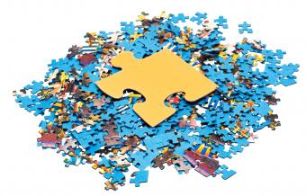 a large yellow puzzle piece on top of a pile of smaller puzzle pieces