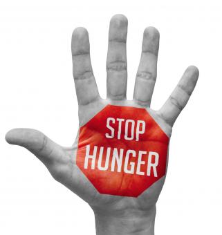Stop hunger sign painted on an open hand raised, isolated on white background.