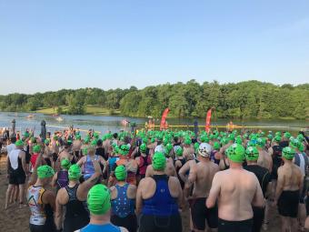 Large group of race participants waiting to enter the lake for the swim portion or the event.