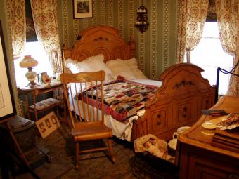 A bed and other furniture in the Cody-McCausland house bedroom.
