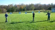 Students lining up bow and arrow on a target.