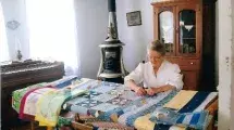 A woman quilting in one of the historic buildings.