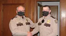 Conservation Executive Director Roger Kean shaking new Park Ranger Brad Taylor's hand. 