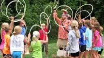 Campers playing with hula-hoops during an indian presentation.