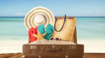 Suitcase filled with sand and beach gear.