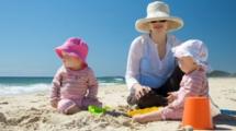 Mom at the beach with her two infant children.