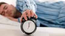 Man sleeping with alarm clock.