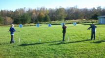 Students lining up bow and arrow on a target.