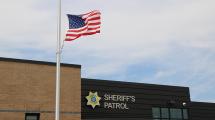 Sheriff Patrol Headquarters building with flag flying in foreground.