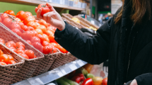 This is an image of a woman shopping for vegetables wearing a medical face mask. 