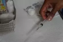Hand holding a syringe. 
